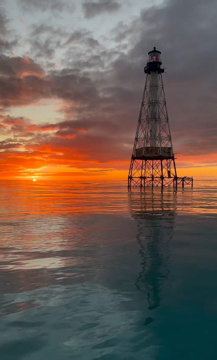 Lighthouse at sunset over calm reef waters