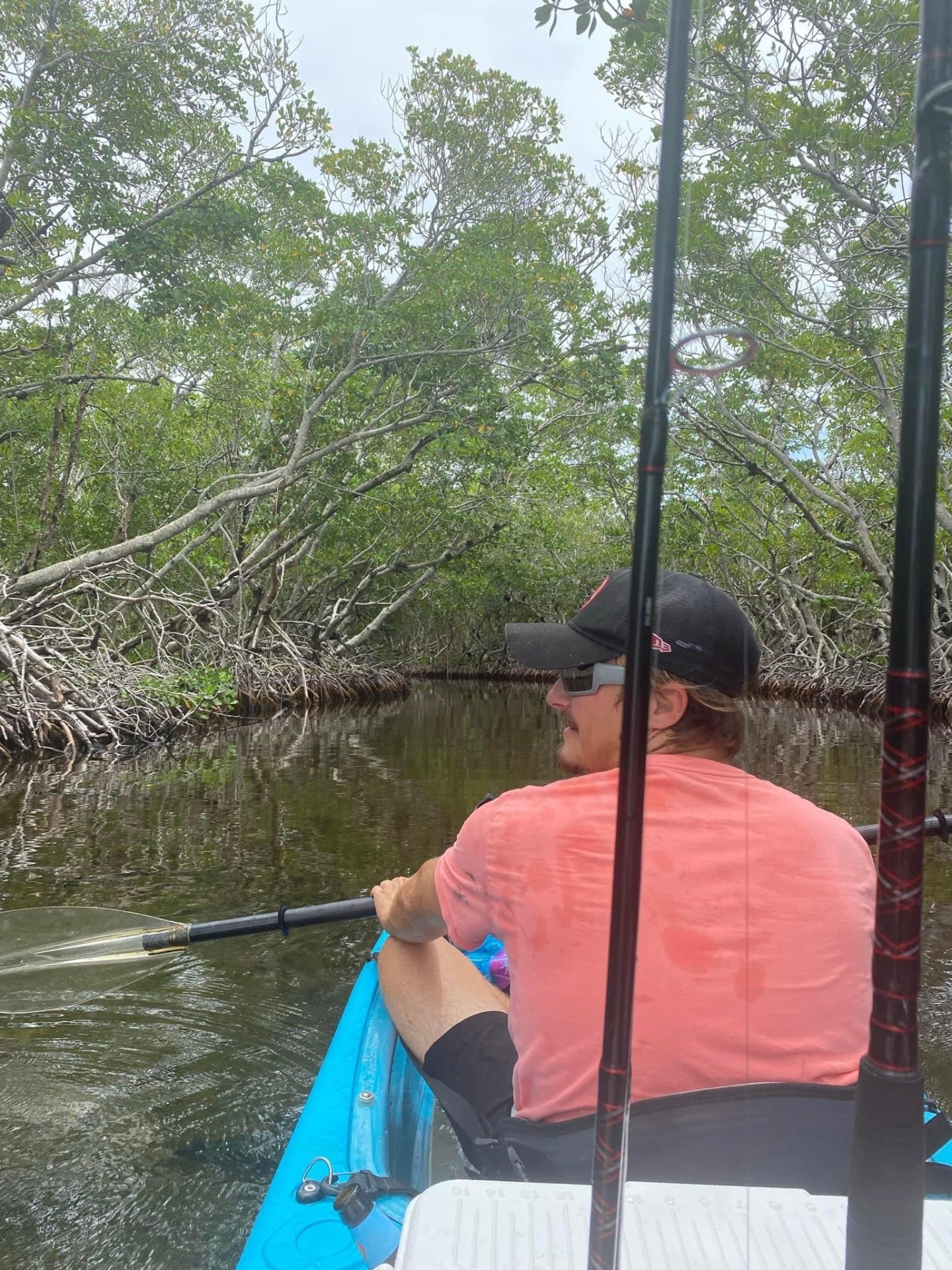 Kayak fishing through a mangrove tunnel