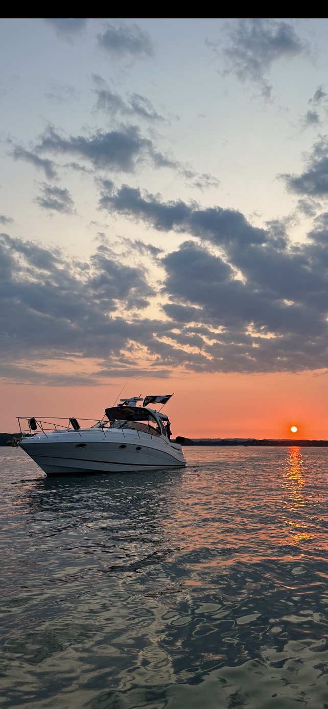 Boat anchored at sunset with dramatic clouds