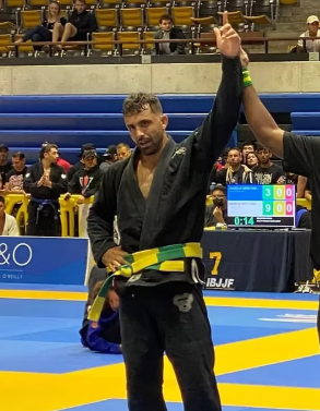 Competitor with hand raised in victory at IBJJF tournament